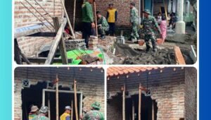 Anggota Satgas TMMD Ke-127 Kodim 0819/Pasuruan sedang memasang kusen pintu saat merehabilitasi Rumah Tidak Layak Huni (RTLH) di Dusun Kili, Desa Wonosari, Kabupaten Pasuruan.