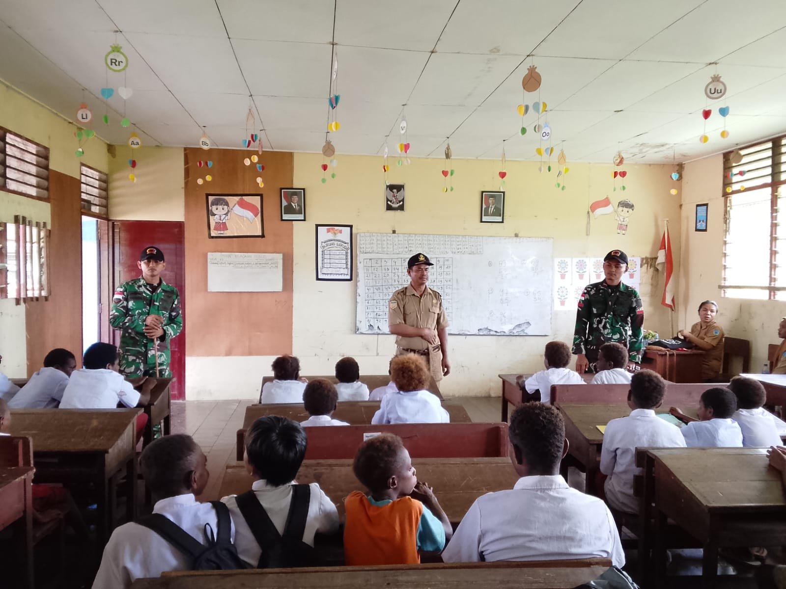 Personel Satgas Yonif 123/Rajawali menyerahkan bantuan pendidikan kepada siswa di Papua Selatan. Alt text: Bantuan pendidikan, Satgas Yonif 123/Rajawali, anak Papua, alat tulis sekolah