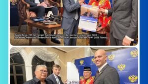 Tolchenov menerima cenderamata kalender PPWI 2026 dari Wilson Lalengke (Ketum PPWI), sekaligus memberikan kalender khusus Kedubes Rusia 2026 sambil menjelaskan foto-fotonya, dengan beberapa tamu undangan yang hadir.