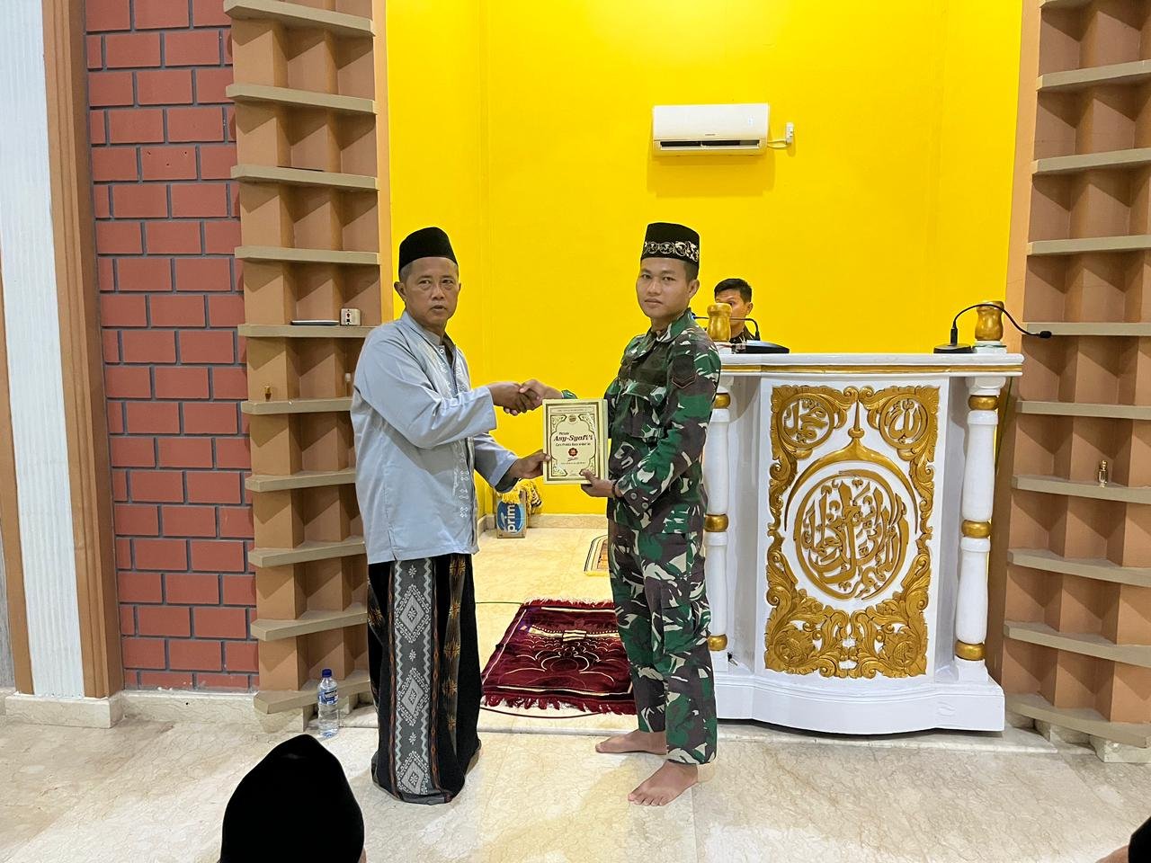 Personel Satgas Yonif 123/Rajawali bersama pengurus Masjid Al-Huda saat proses penyerahan paket kitab suci Al-Qur'an dan buku Iqra di Distrik Edera, Kabupaten Mappi.