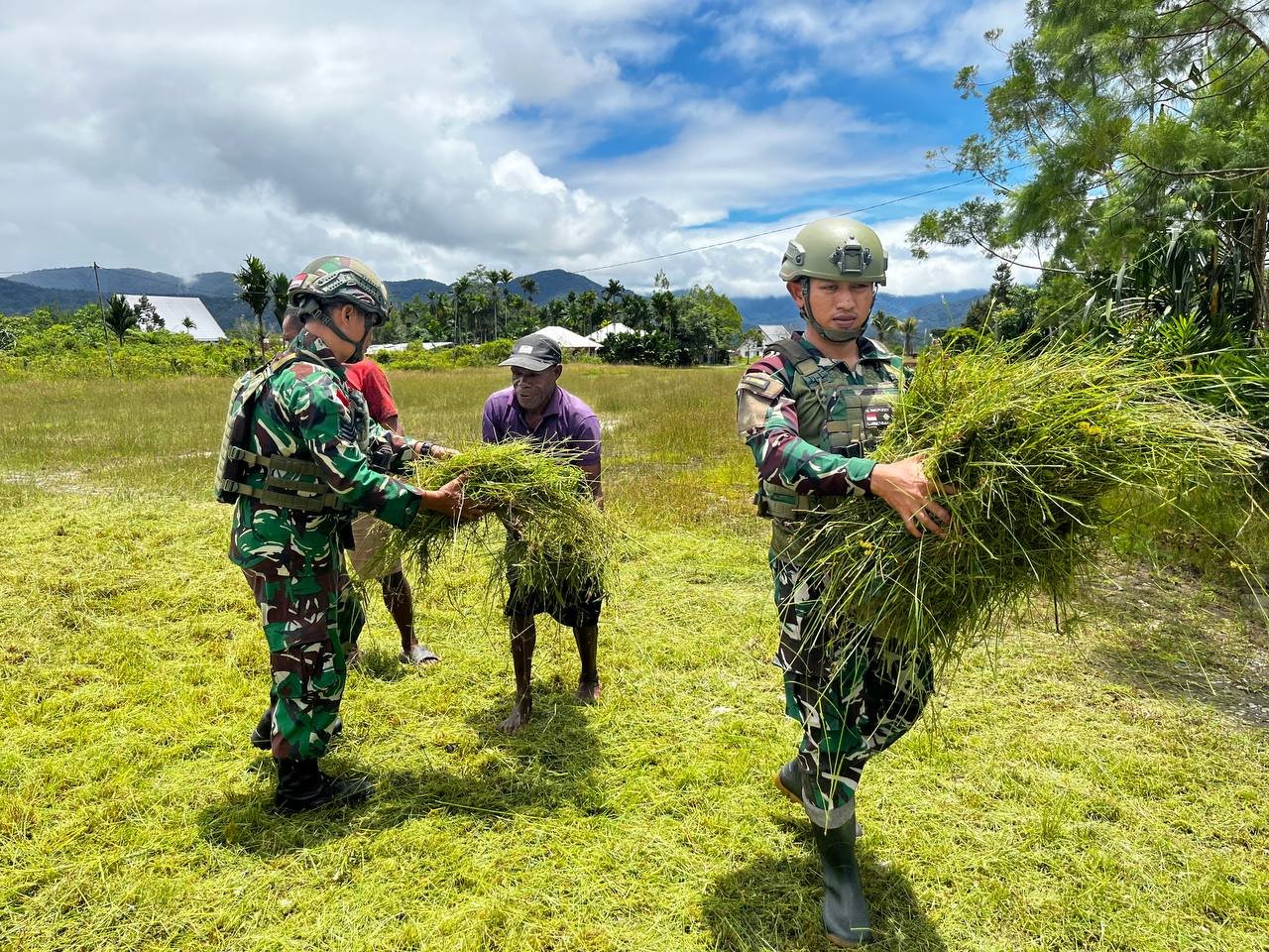 Personel Satgas Yonif 521/DY bersama warga Distrik Elelim Kabupaten Yalimo bergotong royong membersihkan lingkungan pemukiman.