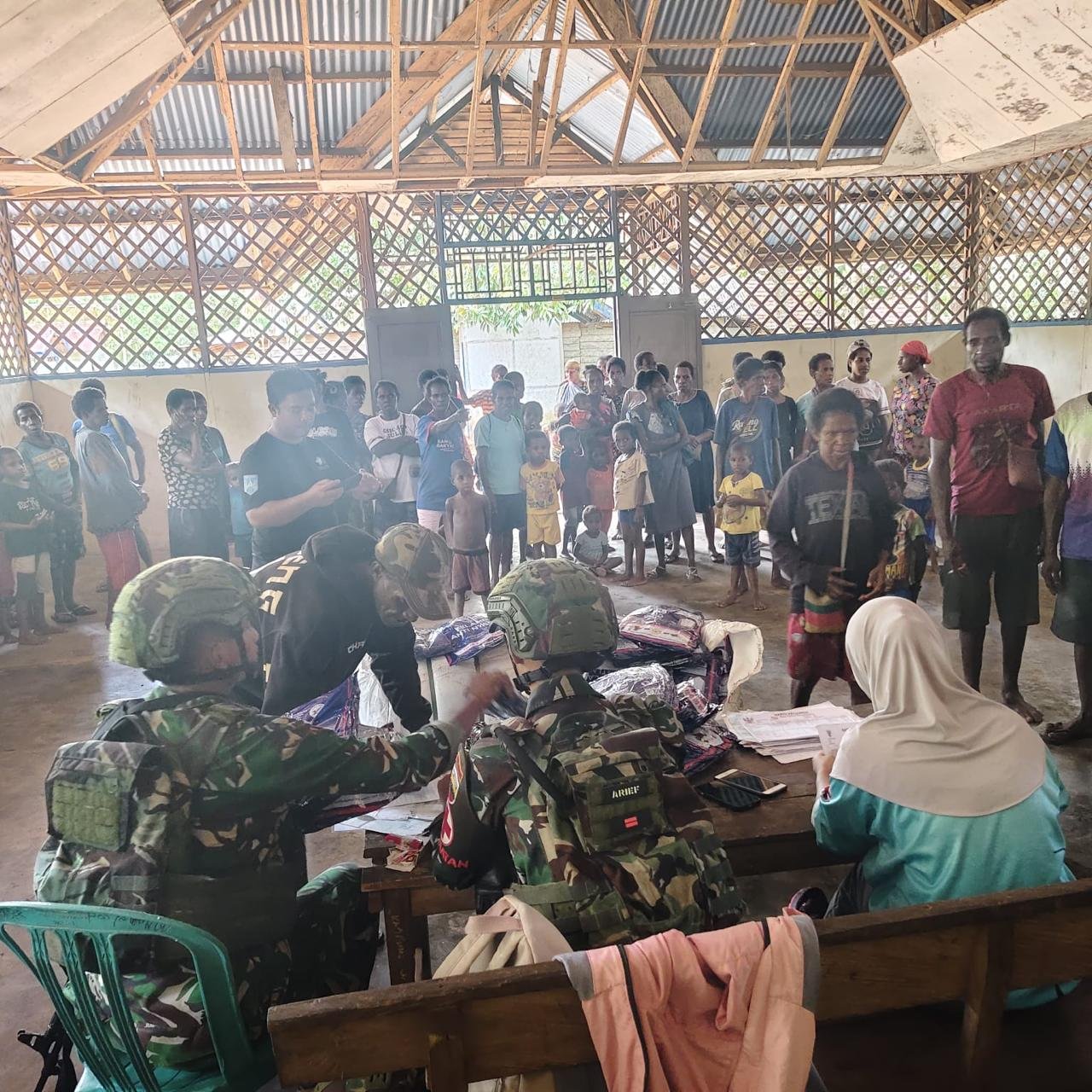 Personel Satgas Pamtas Yonif 123/Rajawali bersama petugas Puskesmas membagikan kelambu anti nyamuk kepada warga di perbatasan Papua. - thewasesaness.com