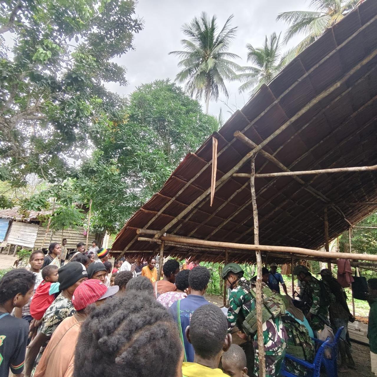 Personel Satgas Pamtas Yonif 123/Rajawali bersama petugas Puskesmas membagikan kelambu anti nyamuk kepada warga di perbatasan Papua. - thewasesanews.com