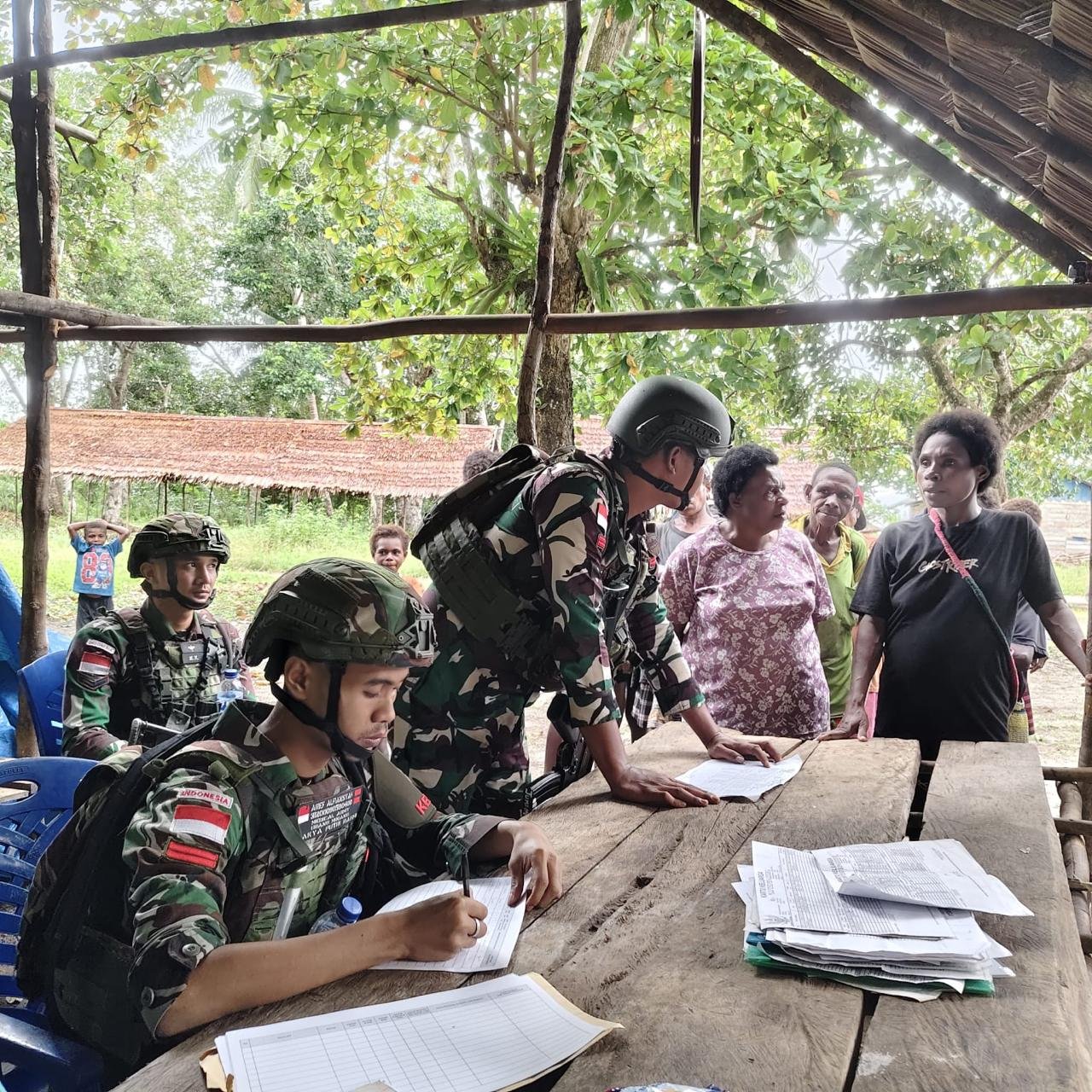 Personel Satgas Pamtas Yonif 123/Rajawali bersama petugas Puskesmas membagikan kelambu anti nyamuk kepada warga di perbatasan Papua. - thewasesaness.com