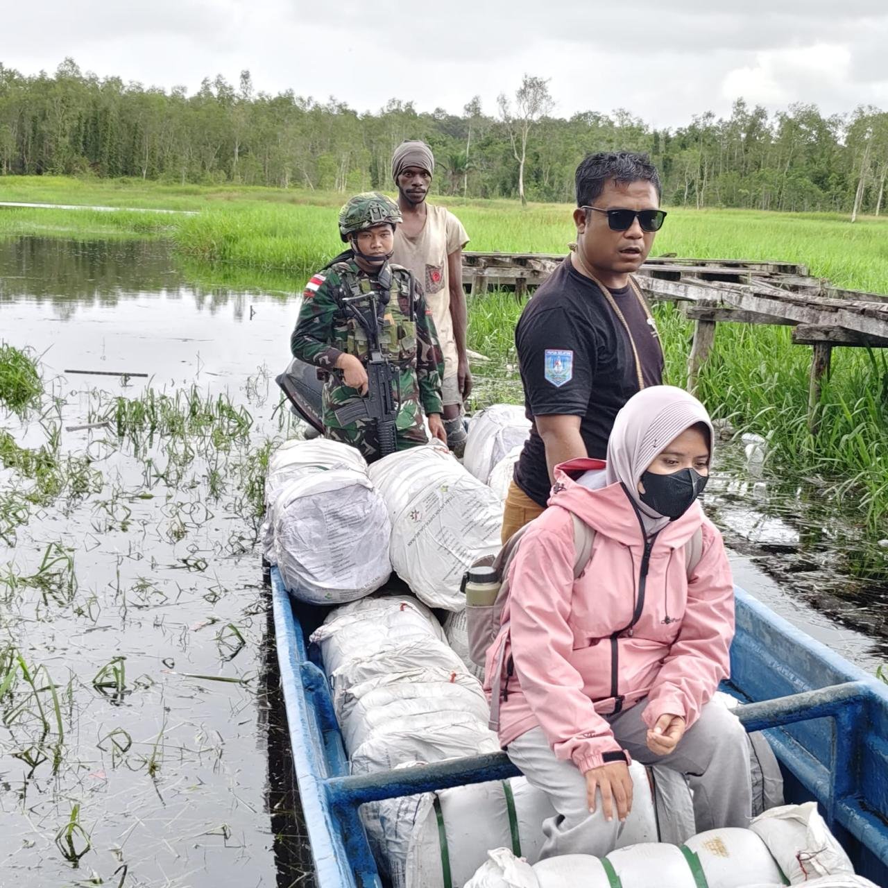 Personel Satgas Pamtas Yonif 123/Rajawali bersama petugas Puskesmas membagikan kelambu anti nyamuk kepada warga di perbatasan Papua. - thewasesanews.com