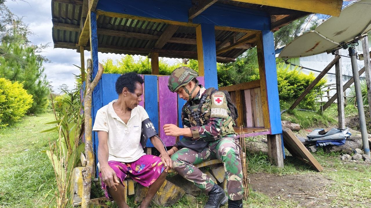 Personel Satgas Yonif 521/DY memberikan pelayanan kesehatan gratis kepada warga Distrik Kurima. - thewasesanews.com