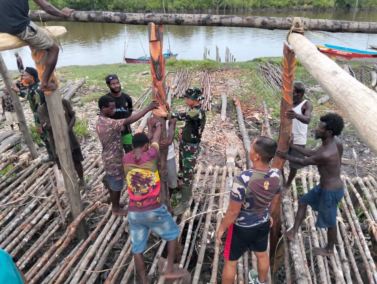 Prajurit Satgas Yonif 123/Rajawali membantu warga membangun Rumah Adat Jew di Kampung Basim Asmat. - thewasesanews.com