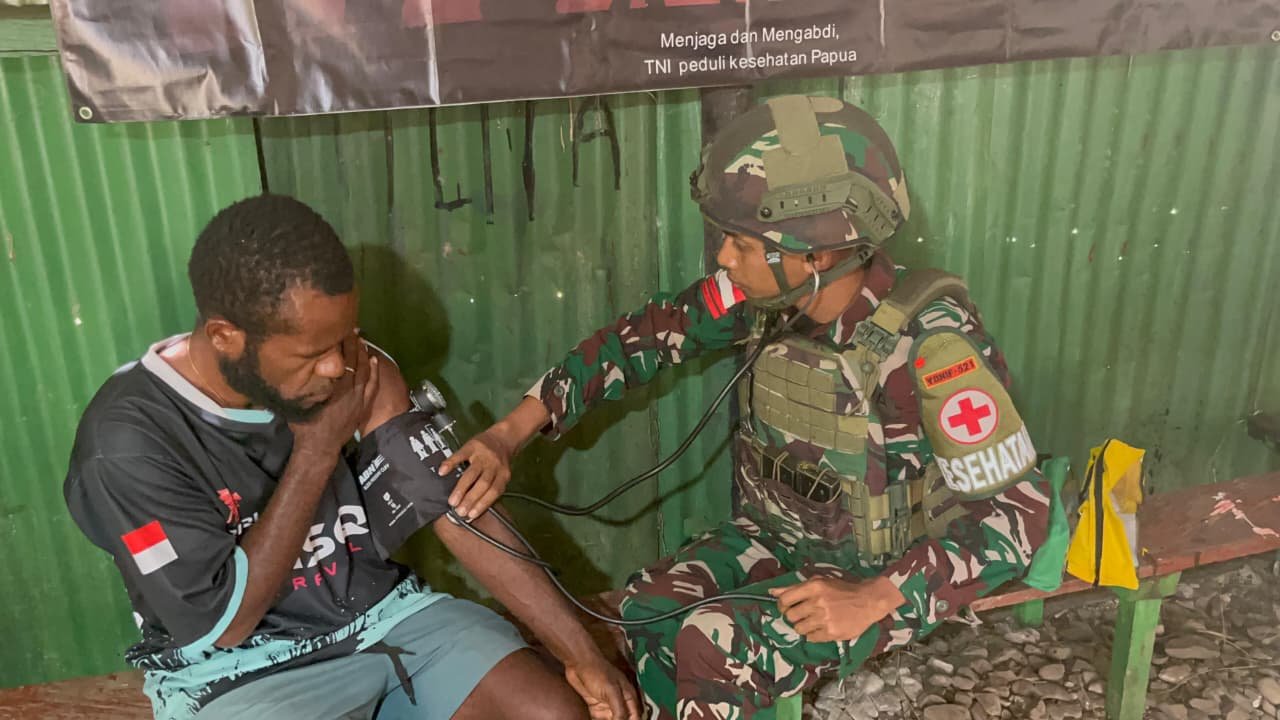 Personel Satgas Yonif 521/DY memberikan pelayanan kesehatan gratis kepada warga di Pos Bolakme. - thewasesanews.com