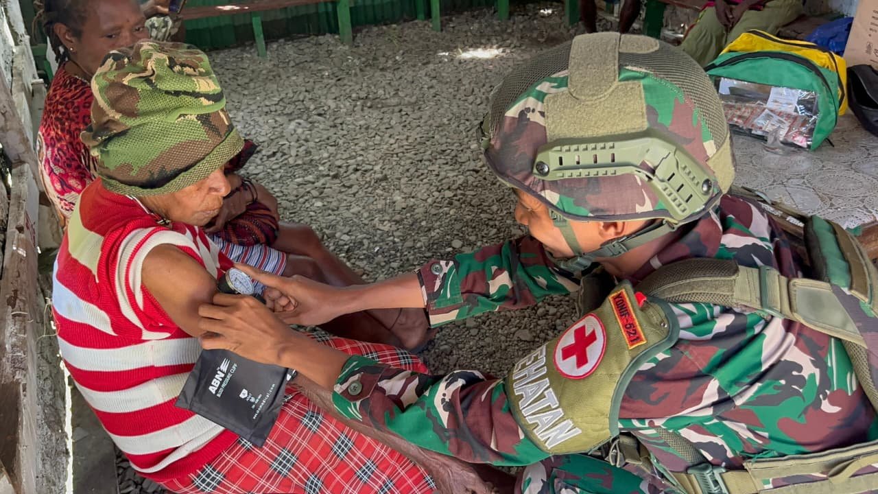 Personel Satgas Yonif 521/DY memberikan pelayanan kesehatan gratis kepada warga di Pos Bolakme.- thewasesanews.com