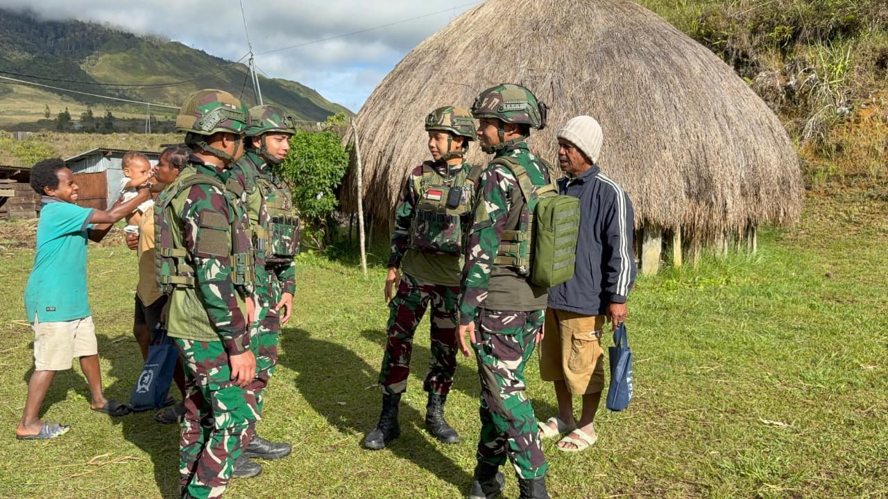 Personel Satgas Yonif 521/DY berbincang hangat dengan Kepala Kampung Napua saat kegiatan anjangsana. - thewasesaness.com