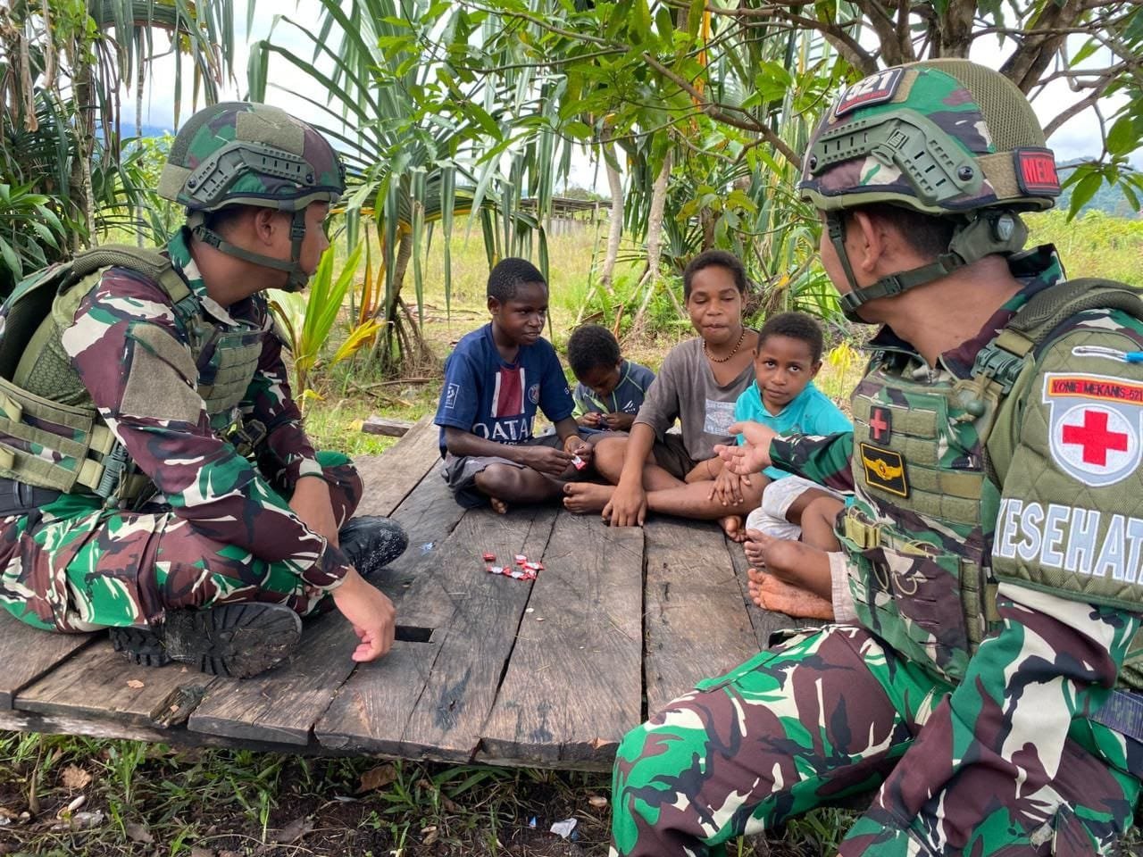 Prajurit kesehatan Satgas Yonif 521/DY memberikan permen kepada anak-anak di Elelim. - thewasesanews.com