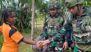 Prajurit Satgas Yonif 521/DY berjabat tangan dengan warga Elelim saat pelayanan kesehatan. - thewasesanews.com