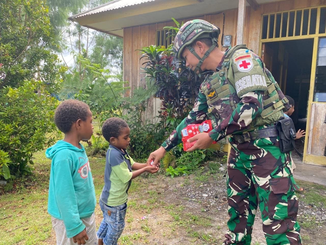 Prajurit Satgas Yonif 521/DY memberikan bingkisan kepada anak-anak di Distrik Elelim. - thewasesaness.com