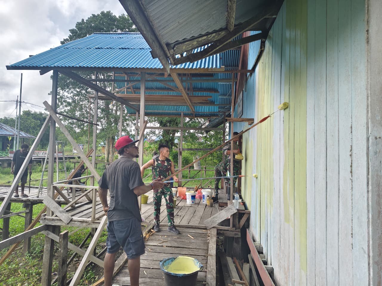 Personel Satgas Yonif 123/Rajawali bersama warga Kampung Binam saat mengecat dan membersihkan gereja di Distrik Suator, Asmat. - thewasesanews.com