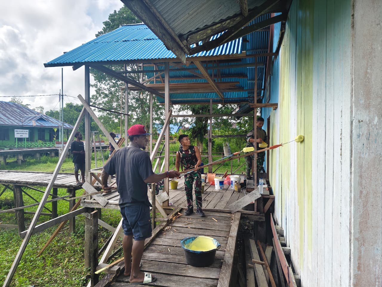 Personel Satgas Yonif 123/Rajawali bersama warga Kampung Binam saat mengecat dan membersihkan gereja di Distrik Suator, Asmat. - thewasesanews.com