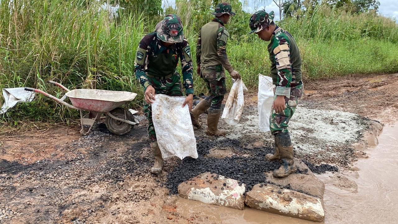 Personel Satgas Yonif 123/Rajawali bersama warga Kimaam bahu-membahu memperbaiki jalan rusak yang menghubungkan akses ke Pelabuhan Kimaam. - thewasesanews.com