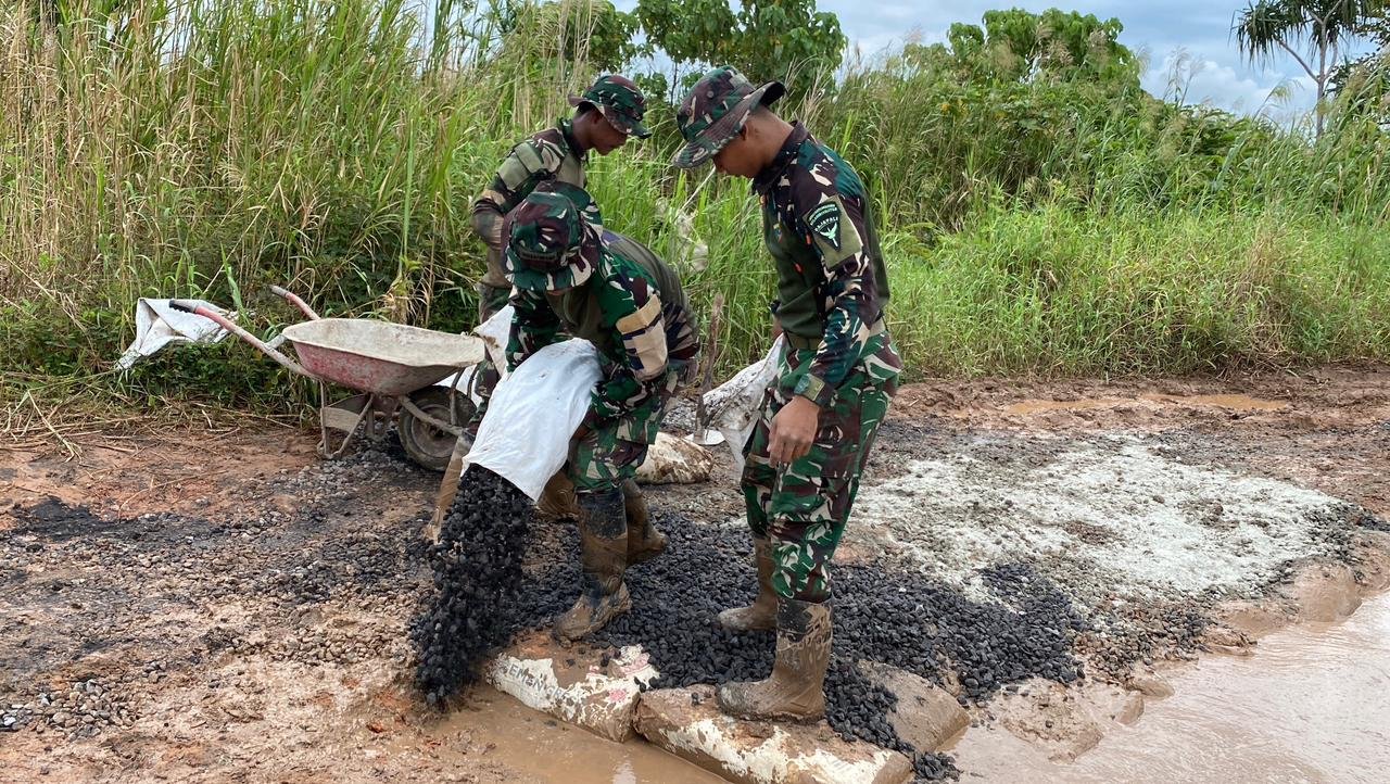 Personel Satgas Yonif 123/Rajawali bersama warga Kimaam bahu-membahu memperbaiki jalan rusak yang menghubungkan akses ke Pelabuhan Kimaam. - thewasesanes.com