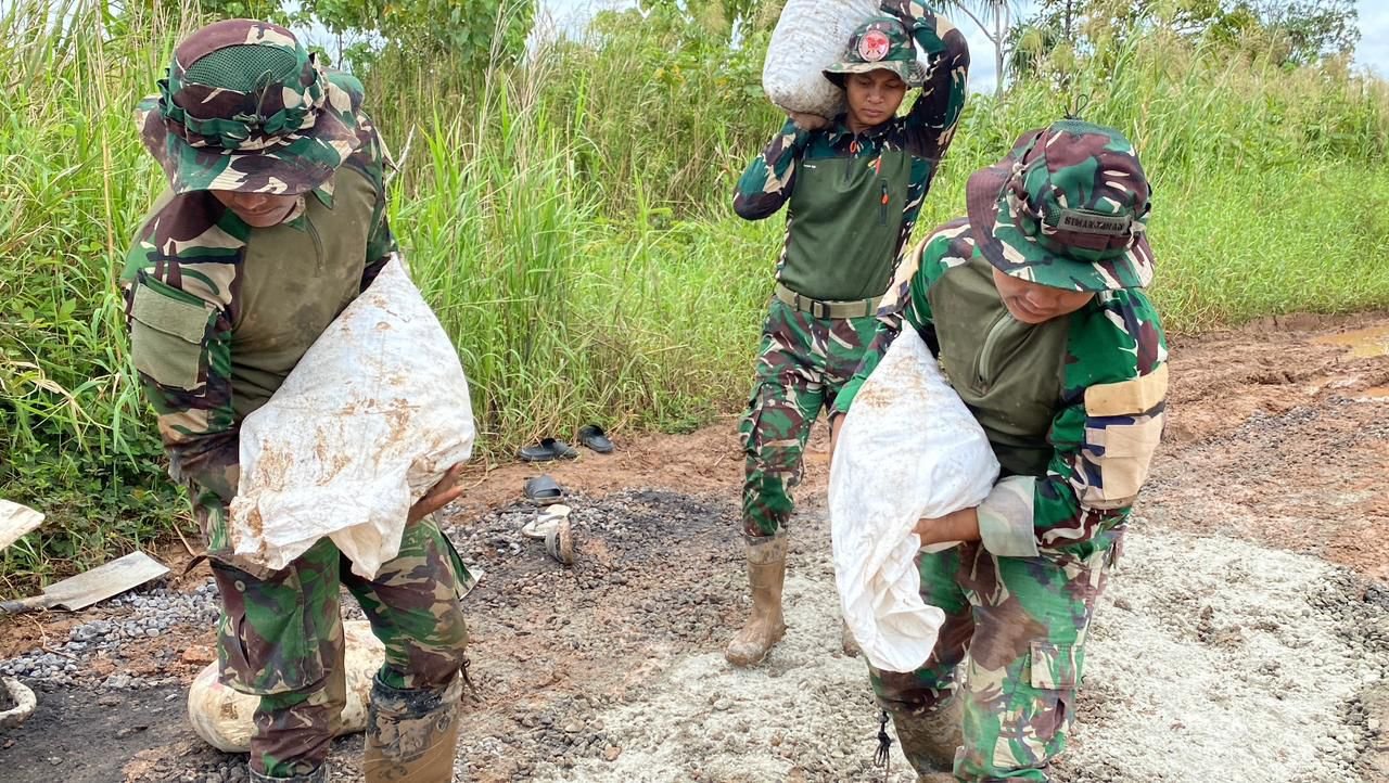 Personel Satgas Yonif 123/Rajawali bersama warga Kimaam bahu-membahu memperbaiki jalan rusak yang menghubungkan akses ke Pelabuhan Kimaam. - thewasedanews.com