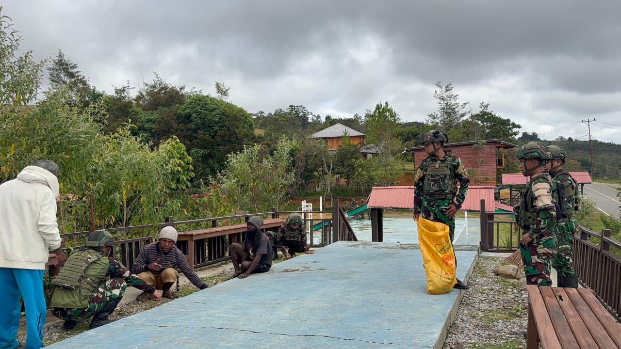 Personel Satgas Yonif 521/DY bahu-membahu bersama warga Distrik Napua membersihkan sampah di kawasan objek wisata Papua Pegunungan. - thewasesanews.com