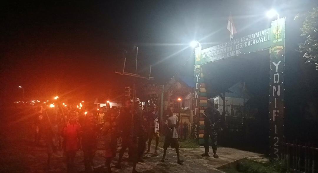 Kebersamaan personel Satgas Yonif 123/Rajawali Pos Kaibar bersama masyarakat Suku Asmat Darat saat menyalakan api unggun malam Paskah di pedalaman Papua. - thewasesanews.com