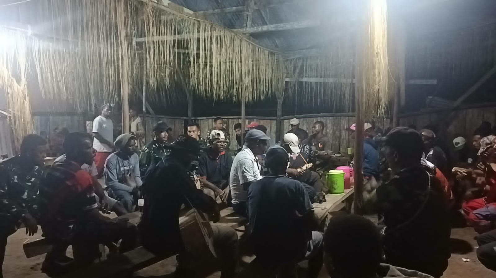 Kebersamaan personel Satgas Yonif 123/Rajawali Pos Kaibar bersama masyarakat Suku Asmat Darat saat menyalakan api unggun malam Paskah di pedalaman Papua. - thewasedanews.com