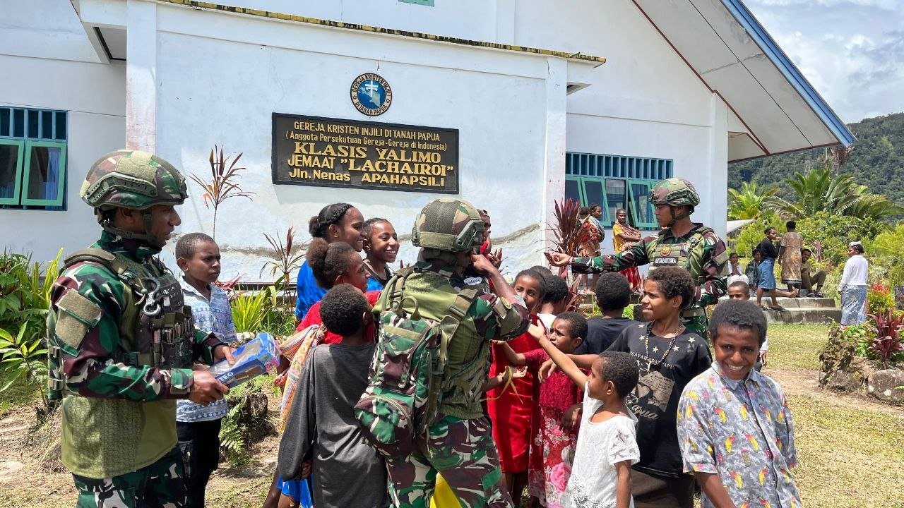 Prajurit Satgas Yonif 521/DY saat membagikan makanan ringan dan memberikan motivasi kepada anak-anak di Distrik Apalapsili, Kabupaten Yalimo. - thewasesanews.com