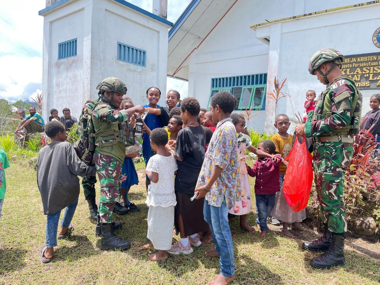Prajurit Satgas Yonif 521/DY saat membagikan makanan ringan dan memberikan motivasi kepada anak-anak di Distrik Apalapsili, Kabupaten Yalimo. - thewasesanews.com
