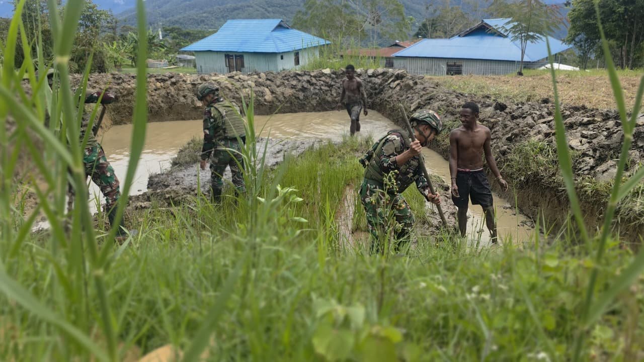 Prajurit Satgas Yonif 521/DY bersama warga Distrik Eragayam bergotong royong membangun kolam ikan budidaya sebagai sarana ketahanan pangan. - thewasedanews.com