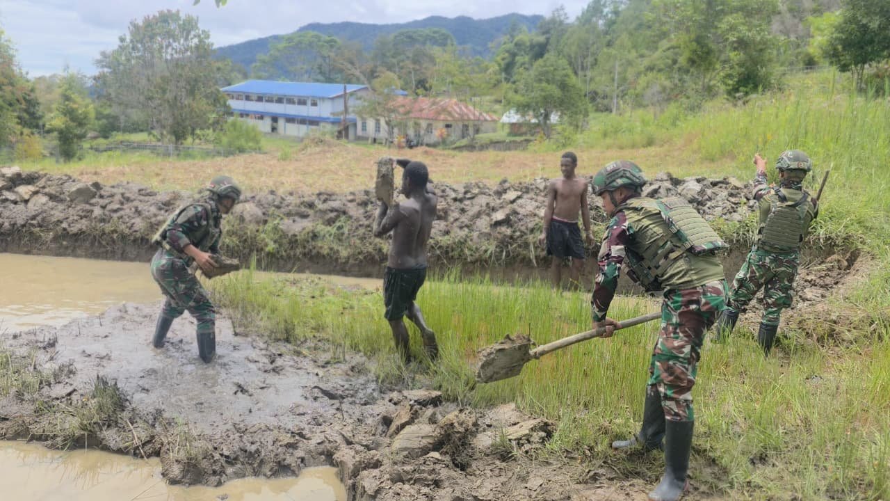Prajurit Satgas Yonif 521/DY bersama warga Distrik Eragayam bergotong royong membangun kolam ikan budidaya sebagai sarana ketahanan pangan. - thewasesanews.com