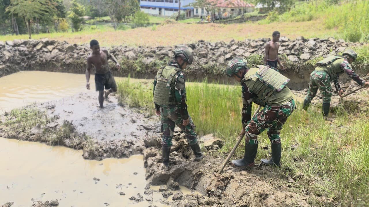 Prajurit Satgas Yonif 521/DY bersama warga Distrik Eragayam bergotong royong membangun kolam ikan budidaya sebagai sarana ketahanan pangan. - thewasedanews.com