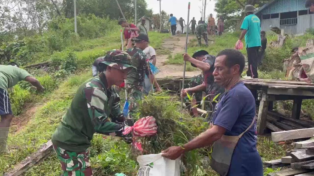 Personel Yonif 123 Rajawali bersama anak-anak SD dan warga Kampung Sahapikya sedang membersihkan area pelabuhan dari sampah plastik dan genangan air. - thewasesanews.com