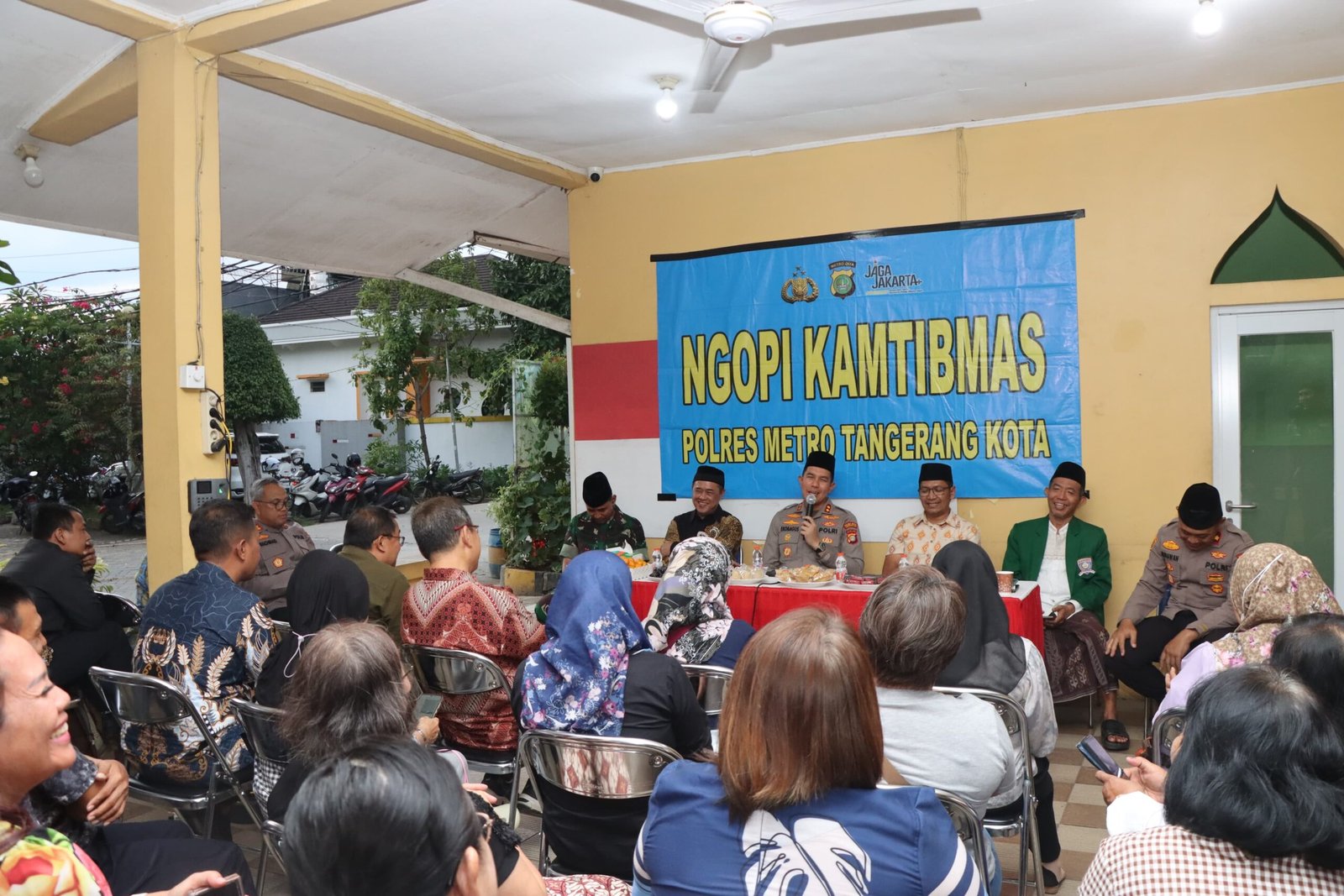 Foto Wakapolres Metro Tangerang Kota AKBP Eko Bagus Riyadi saat memberikan kentongan kepada warga perumahan Simprug Poris Jaya dalam kegiatan Ngopi Kamtibmas Polres Tangerang untuk bahas keamanan. - thewasesanws.com