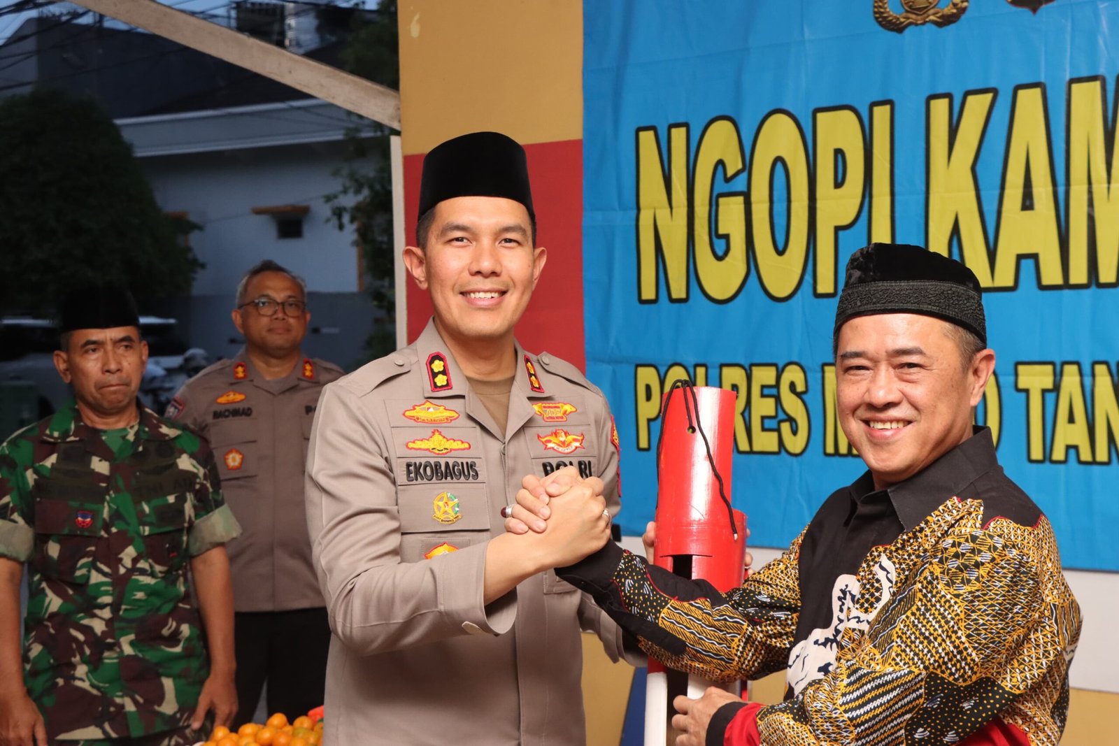 Foto Wakapolres Metro Tangerang Kota AKBP Eko Bagus Riyadi saat memberikan kentongan kepada warga perumahan Simprug Poris Jaya dalam kegiatan Ngopi Kamtibmas Polres Tangerang untuk bahas keamanan. - thewasesanews.com