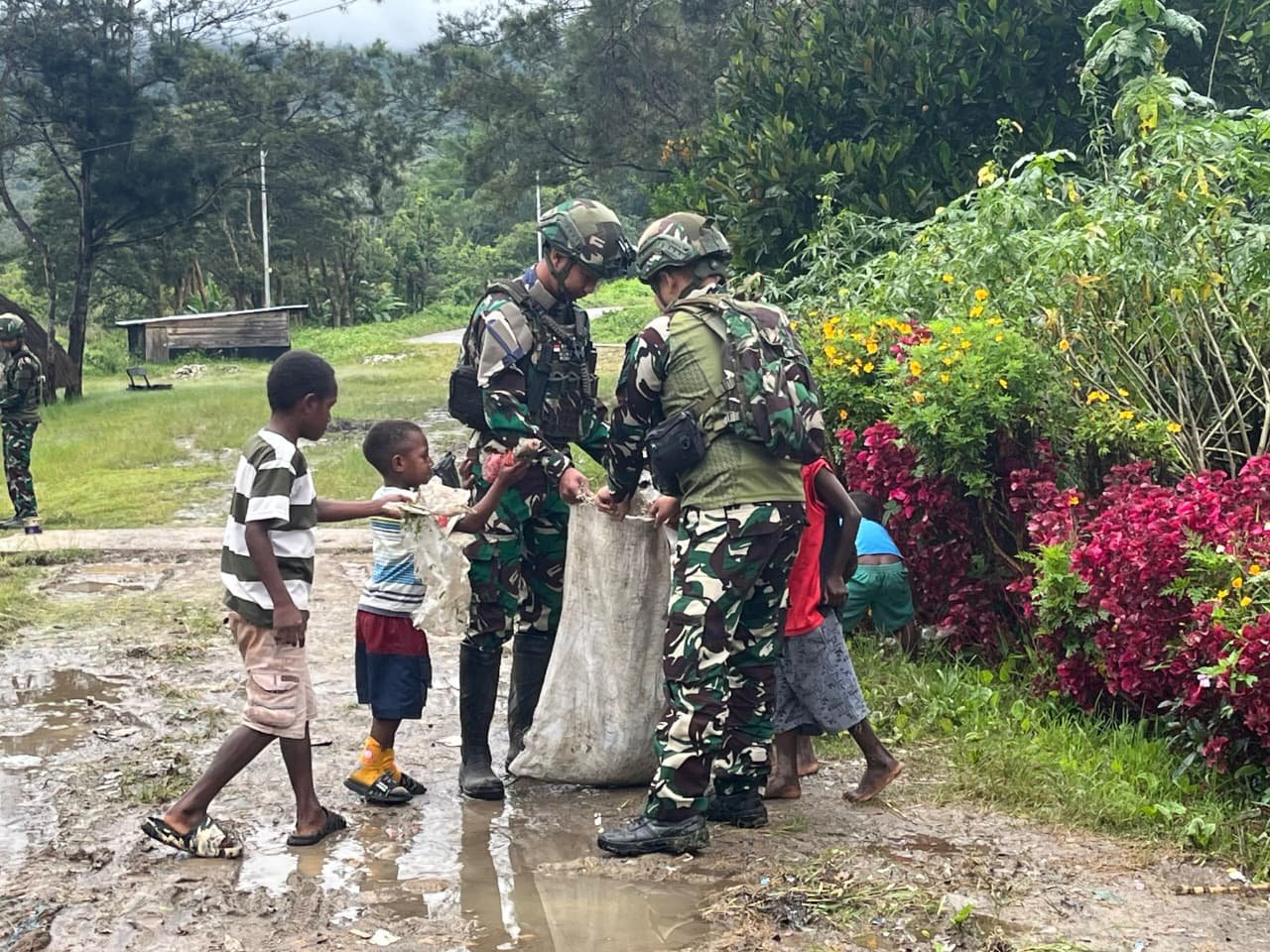 Prajurit Satgas Yonif 521/DY bersama anak-anak dan warga bergotong royong membersihkan rumput liar di jalan utama Kampung Bolakme Papua Pegunungan pada 10 April 2026. - thewasesanews.com