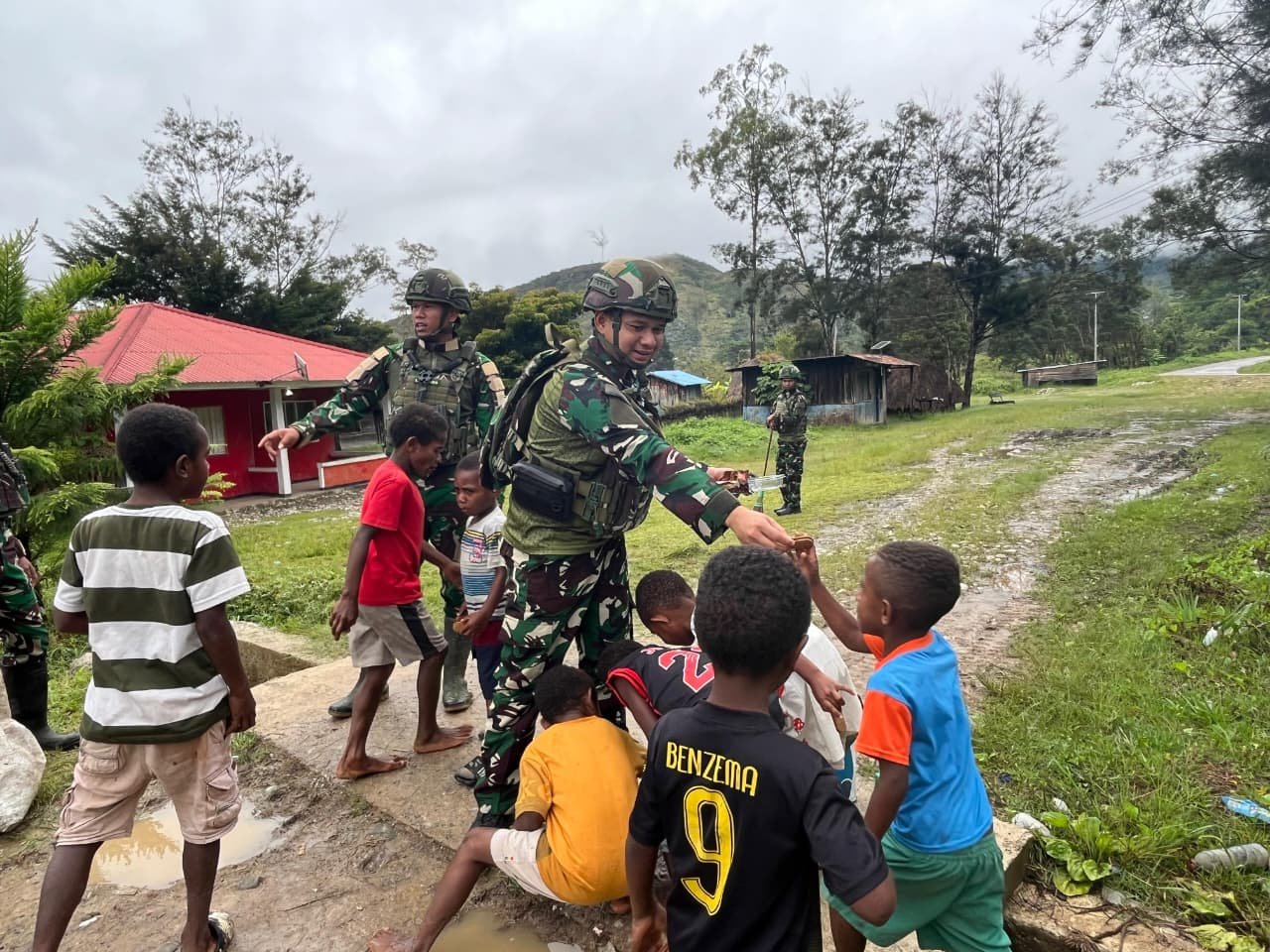 Prajurit Satgas Yonif 521/DY bersama anak-anak dan warga bergotong royong membersihkan rumput liar di jalan utama Kampung Bolakme Papua Pegunungan pada 10 April 2026. - thewasesanews.com