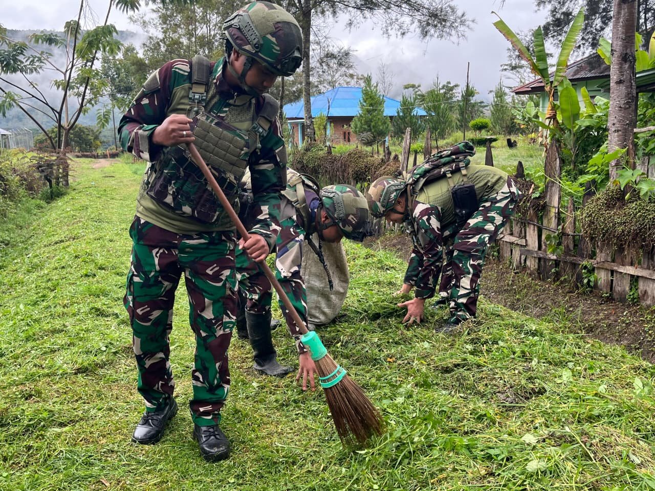 Prajurit Satgas Yonif 521/DY bersama anak-anak dan warga bergotong royong membersihkan rumput liar di jalan utama Kampung Bolakme Papua Pegunungan pada 10 April 2026. - thewasesanews.com