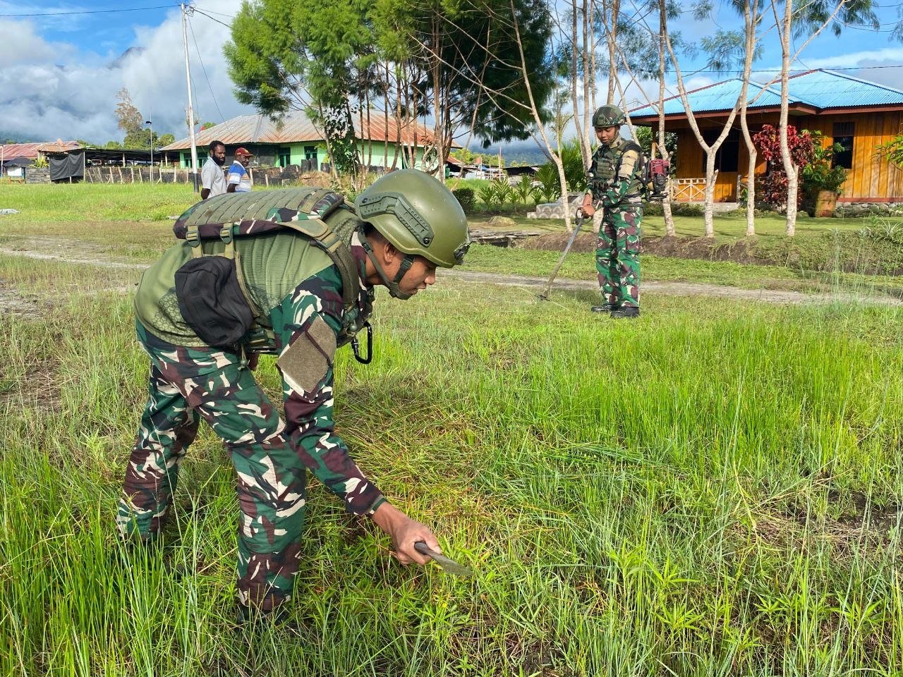 Personel Satgas Yonif 521/DY bersama warga Elelim Yalimo melakukan karya bakti pembersihan jalan kampung. - thewasesanews.com