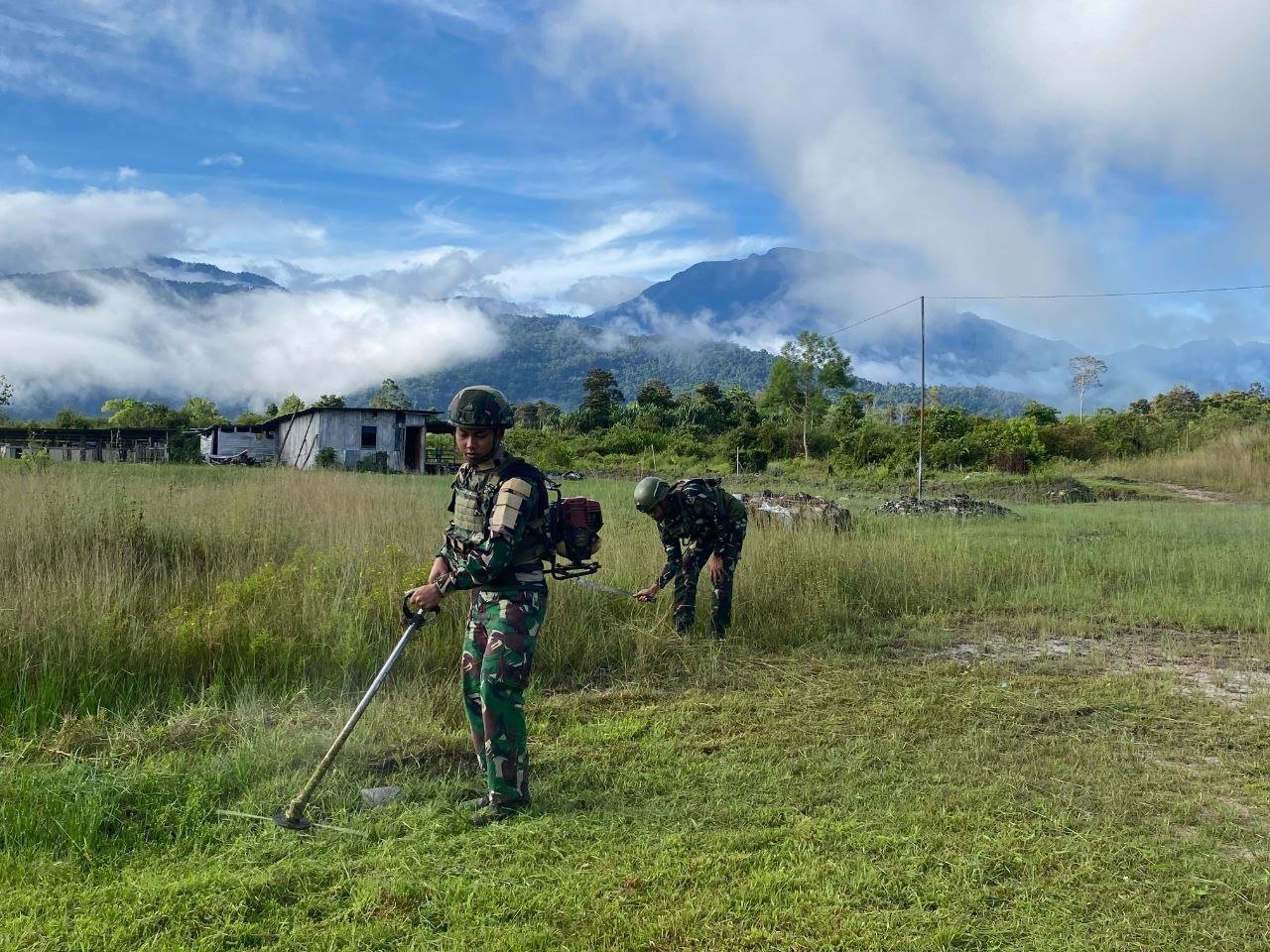 Personel Satgas Yonif 521/DY bersama warga Elelim Yalimo melakukan karya bakti pembersihan jalan kampung. - thewasesanews.com