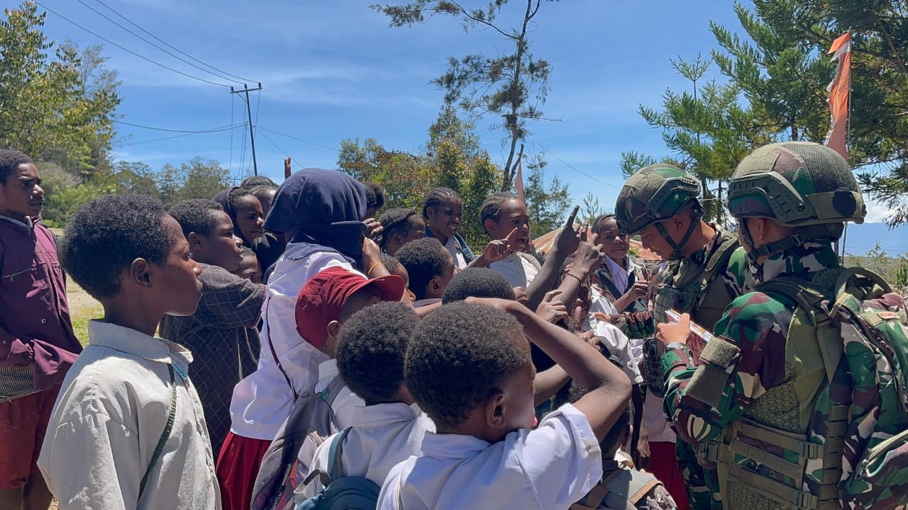 Prajurit Satgas Yonif 521/DY membagikan buku bacaan kepada anak-anak sekolah di Distrik Napua Papua Pegunungan guna tingkatkan literasi. - thewasesanews.com
