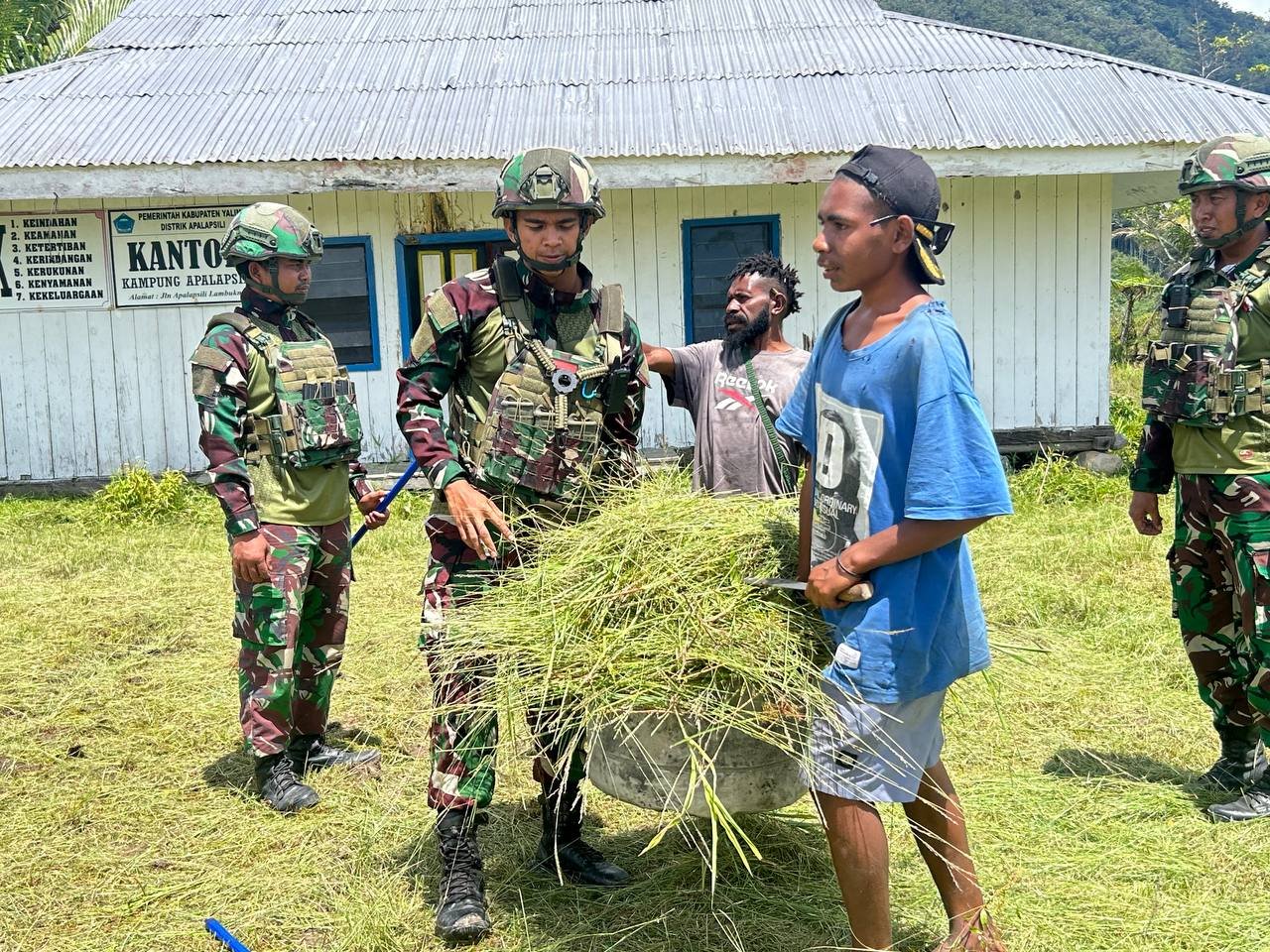 Personel Satgas Yonif 521 DY bersama masyarakat Desa Apalapsili saat melaksanakan karya bakti membersihkan halaman Kantor Desa Apalapsili Yalimo. - thewasesanews.com