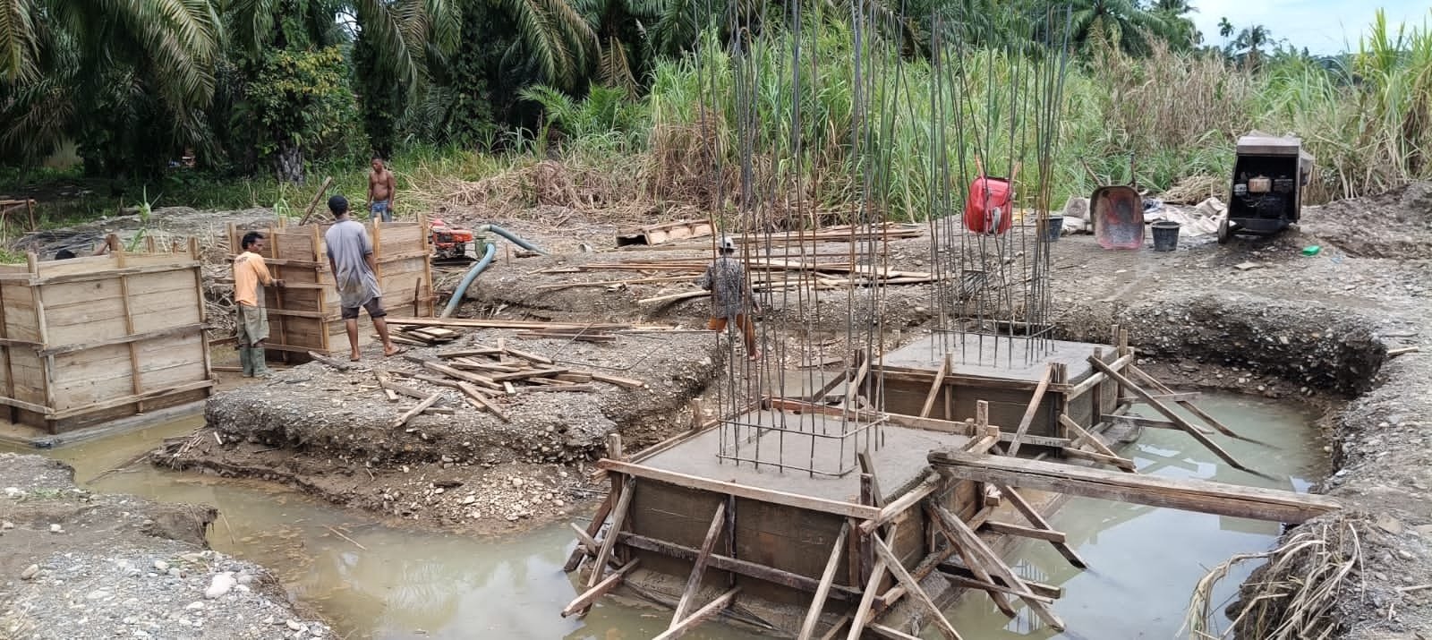 Personel Koramil 09/Sosa Kodim 0212/TS bersama warga Desa Parapat melakukan pengecoran pondasi jembatan gantung di Kecamatan Ulu Sosa. - thewasesnews.com