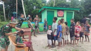 Personel Satgas Yonif 123/Rajawali pangkas rambut anak-anak di kampung binaan perbatasan Papua sebagai bentuk kepedulian humanis. - thewasesanews.com