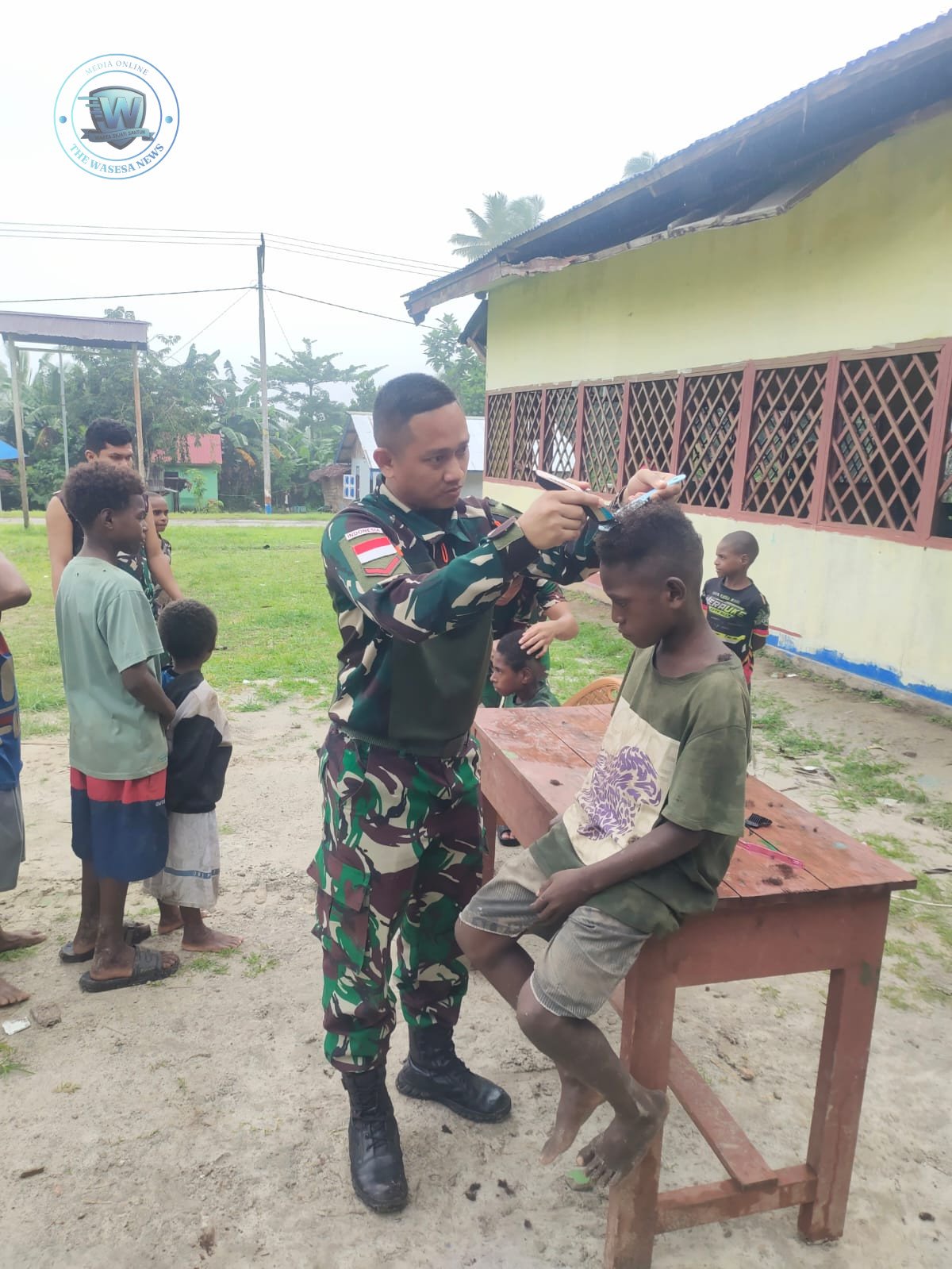 Personel Satgas Yonif 123/Rajawali pangkas rambut anak-anak di kampung binaan perbatasan Papua sebagai bentuk kepedulian humanis. - thewasesanews.com