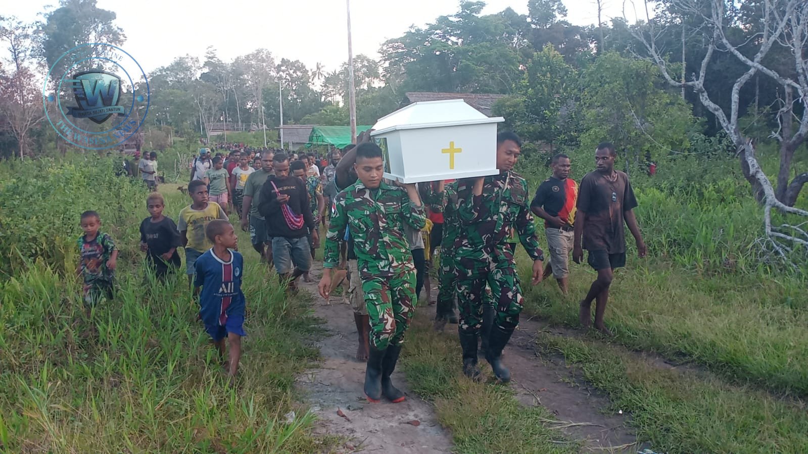 Personel Satgas Yonif 123/Rajawali membantu mengangkat jenazah warga Kampung Wonggi Papua saat prosesi pemakaman. - thewasesanews.com
