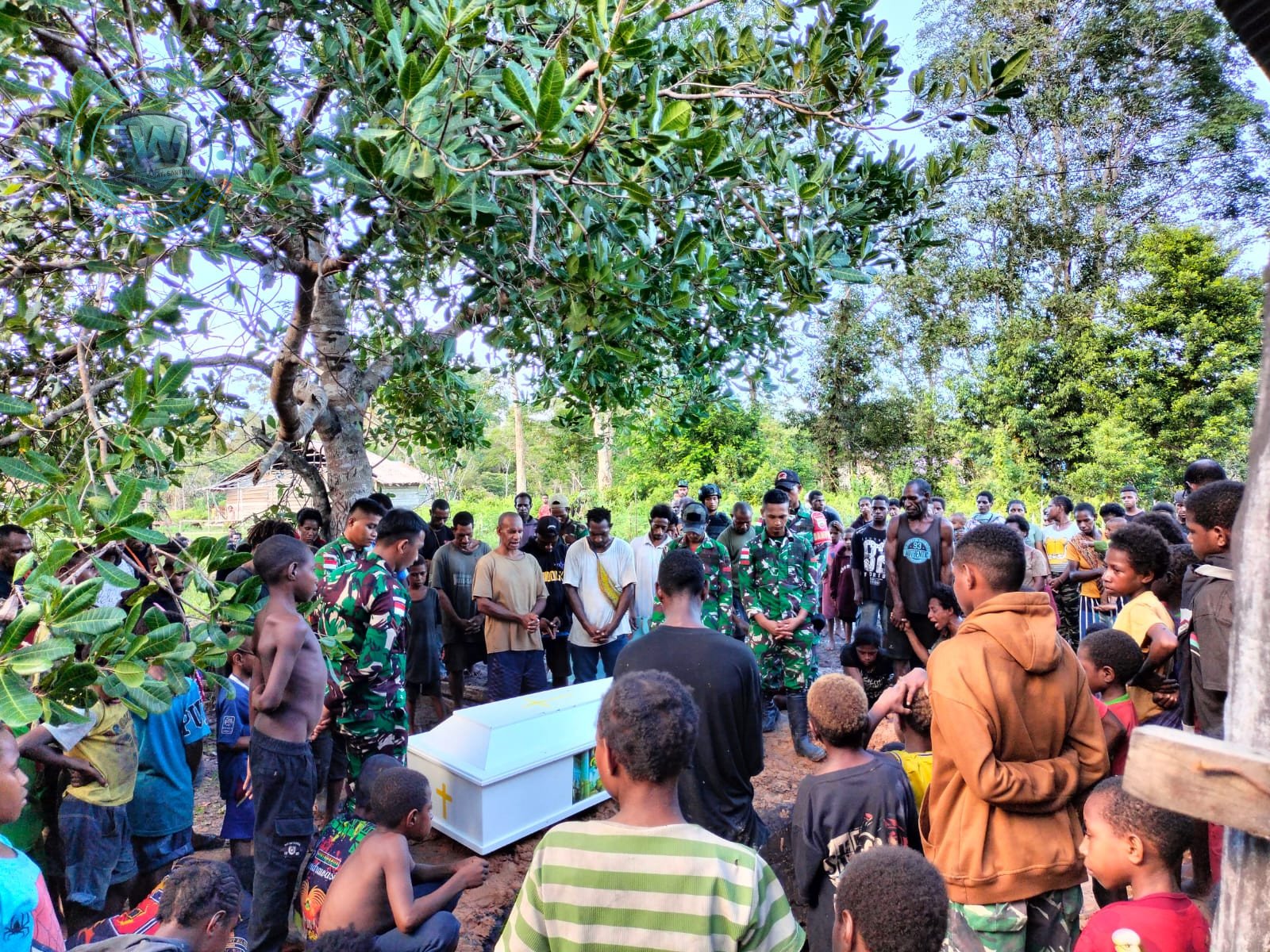 Personel Satgas Yonif 123/Rajawali membantu mengangkat jenazah warga Kampung Wonggi Papua saat prosesi pemakaman. - thewasesanews.com