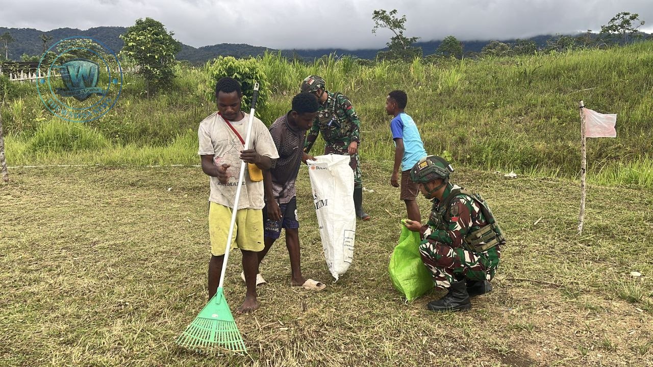 Personel Satgas Yonif 521/DY bersama pemuda Kobakma melaksanakan karya bakti pembersihan lapangan sepak bola di Mamberamo Tengah. - thewasedanews.com