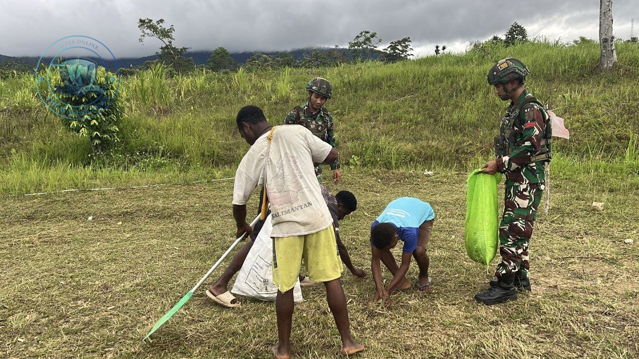 Personel Satgas Yonif 521/DY bersama pemuda Kobakma melaksanakan karya bakti pembersihan lapangan sepak bola di Mamberamo Tengah. - thewasesanews.com