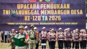 Prajurit Satgas TMMD ke-128 Kodim 1801/Manokwari bersama warga saat mendirikan tiang utama pembangunan rumah layak huni di Kampung Tanah Rubuh. - thewasesanews.com