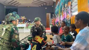 Prajurit Satgas Yonif 521/DY Macan Kumbang saat membagikan Alkitab kepada jemaat Gereja GBI Shekinah di Distrik Elelim Papua Pegunungan. - thewasesanews.com