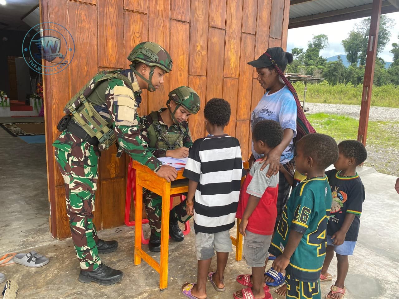 Prajurit Satgas Yonif 521/DY Macan Kumbang saat membagikan Alkitab kepada jemaat Gereja GBI Shekinah di Distrik Elelim Papua Pegunungan. - thewasesanews.com